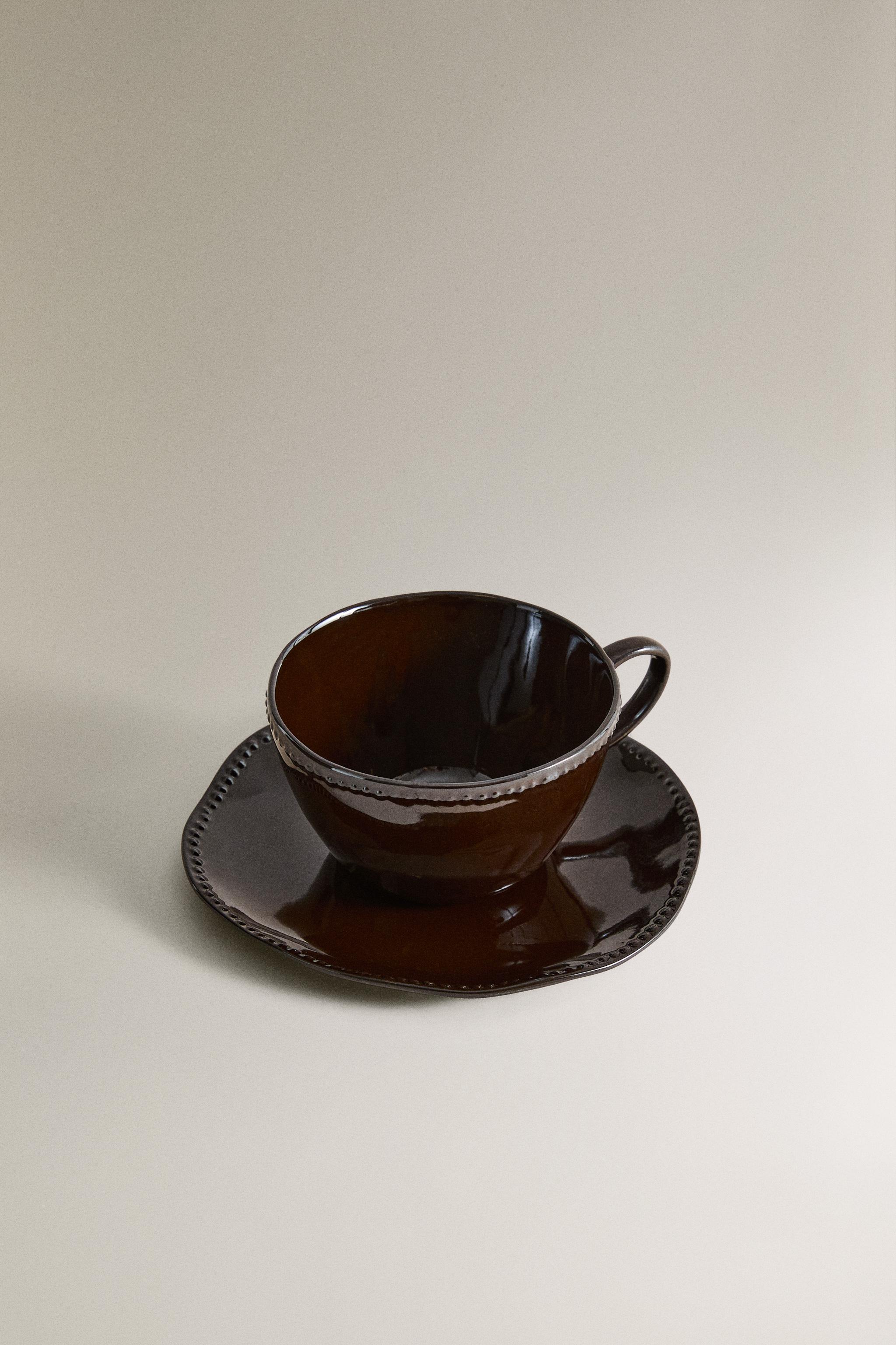 STONEWARE COFFEE CUP AND SAUCER WITH RAISED DESIGN